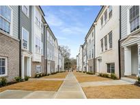 A view of the street with modern townhomes featuring brick and siding exteriors under a clear, bright sky at 3165 Dogwood Dr # 108, Hapeville, GA 30354