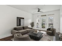Bright living room with hardwood floors, modern furnishings, and access to a private balcony with outdoor seating at 840 United Se Ave # 411, Atlanta, GA 30312