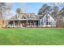 Beautiful craftsman-style home with a blue exterior, large front yard, and charming front porch with wooden posts at 602 Sandhill Hickory Level Rd, Carrollton, GA 30116