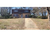Two-story home with a brick facade on the lower half and siding on the upper half and an attached one car garage at 3747 Southland Ct, Atlanta, GA 30344
