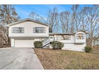 Charming two-story home featuring a bright, white exterior and well-manicured lawn at 5855 Navarre Ct, Stone Mountain, GA 30087