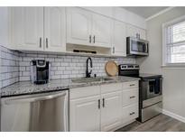 Well-lit kitchen featuring subway tile backsplash, stainless steel appliances, and granite countertops at 6700 Roswell Rd # 32C, Atlanta, GA 30328