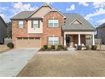 Charming two-story brick home with a welcoming front porch and attached two car garage at 3490 Mulberry Cove Way, Auburn, GA 30011