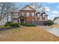 Charming two-story home with a brick and siding exterior, a well-maintained lawn, and mature landscaping at 2295 Hemrick Rd, Cumming, GA 30041