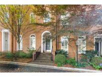 Charming brick townhome featuring an arched doorway and mature landscaping at 3131 Slaton Nw Dr # 22, Atlanta, GA 30305