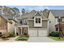 Charming two-story home featuring an attached two-car garage, welcoming front porch, and manicured lawn at 7925 Majors Mill Dr, Cumming, GA 30041