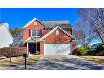 Charming two-story brick home with a two-car garage, lush landscaping and a well-manicured front yard at 1011 Winding Down Way, Grayson, GA 30017