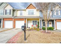 Charming townhome featuring a well-manicured front yard and attached one car garage at 3068 Cedar Glade Ln, Buford, GA 30519