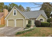Charming home featuring a two-car garage and lush front yard landscaping at 4710 Vineyard Se Ct, Smyrna, GA 30082