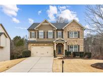 Charming two-story home featuring brick and siding, complemented by a well-manicured lawn and an attached two-car garage at 4240 Hunters Walk Way, Cumming, GA 30028