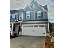 Two-story gray townhome with a two-car garage, gray siding, white trim, and dark blue shutters at 713 Bickmore Dr, Mcdonough, GA 30253