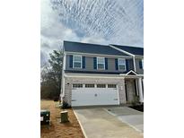 Charming townhouse with a two-car garage, grey siding, and blue shutters at 701 Bickmore Dr, Mcdonough, GA 30253