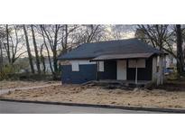Cozy single-story home with a small front porch and partially covered windows in a wooded setting at 516 Warren Ave, Scottdale, GA 30079