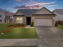 Charming single-story brick home with a well-maintained lawn and attached two-car garage at 6451 Crest Brook Way, Buford, GA 30518