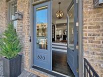 Inviting brick home exterior featuring a stylish front door and well-manicured landscaping, creating a welcoming entrance at 620 Camp Ave, Roswell, GA 30075