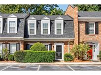 Charming townhome with brick facade, dormer windows, and manicured landscaping at 5 Spring Green Pl, Atlanta, GA 30318