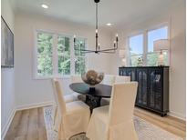 Sun-lit dining area with modern chandelier, and views of the surrounding greenery at 1903 Deco Dr, Kennesaw, GA 30144