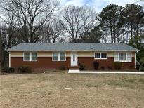 Charming ranch-style home featuring a brick facade and well-manicured landscaping at 5862 Kitchens Se Rd, Mableton, GA 30126