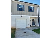 Two-story townhome featuring a one car garage and neutral siding with blue shutters at 4940 Elm Brook Dr, Atlanta, GA 30349