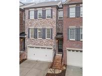 Attractive brick townhome featuring a two-car garage and classic architectural details at 145 Rose Garden Ln, Alpharetta, GA 30009