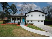 Charming two-story home boasts a beautifully landscaped front yard and a bright blue front door at 1616 W Kellogg Cir, Douglasville, GA 30134