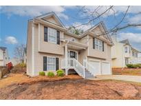Charming two-story home with vinyl siding, black shutters and a two car garage at 6557 Snow Bird Ln, Douglasville, GA 30134