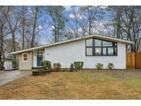 Charming single-story home with painted brick, modern windows, a blue front door and a well maintained front yard at 3180 Vine Cir, Decatur, GA 30033