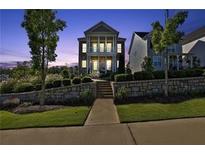 Inviting two-story home featuring a covered porch and meticulously landscaped front yard at twilight at 545 Hanlon Way, Alpharetta, GA 30009