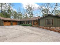 Charming single-story home showcasing a spacious driveway and two-car garage at 4230 N Elizabeth Se Ln, Atlanta, GA 30339