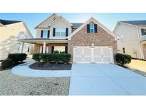 Charming two-story brick home with a well-manicured lawn and a two-car garage at 2378 Misty Ivy Ct, Buford, GA 30519