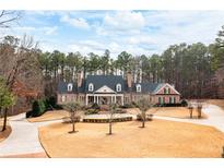 Stately brick home featuring a circular driveway and well-manicured landscaping and covered front porch at 3201 Hobsons Ridge Nw Trl, Acworth, GA 30101