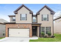 Inviting two-story home featuring a two-car garage, manicured lawn, and stylish architectural details at 4924 Rapahoe Trl, Atlanta, GA 30349
