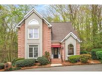 Charming brick home with manicured landscaping, and a red awning over the front door at 1255 Wildcliff Ne Pkwy, Atlanta, GA 30329