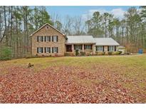 Charming two-story brick home with a metal roof, front porch, and a spacious front yard at 20 Spivey Chase Ln, Jonesboro, GA 30236