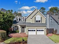 Charming two-story home featuring a well-manicured lawn, brick entryway, and a two-car garage at 545 S Riversong Ln, Roswell, GA 30022