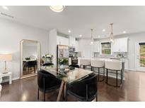 Open concept kitchen and dining space with a large island, modern lighting, and hardwood floors at 2452 Coosa Vly, Atlanta, GA 30339