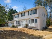 Charming two-story home with brick accents, white siding, and a well-manicured front yard at 4590 Mountain Creek Ne Dr, Roswell, GA 30075