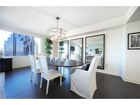 Elegant dining room featuring dark wood floors, large windows, and a stylish chandelier at 75 14Th Ne St # 3820, Atlanta, GA 30309