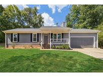 Charming single-story home with gray siding, green lawn, and a welcoming front porch at 1303 Ridgeview Rd, Auburn, GA 30011