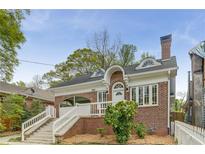 Charming brick home with a well-manicured lawn, white trim, and a cozy front porch at 1626 Rogers Sw Ave, Atlanta, GA 30310