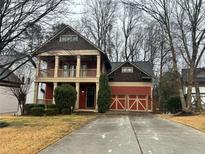 Two-story home featuring a welcoming front porch, two-car garage and concrete driveway at 2313 Bouldercliff Way, Atlanta, GA 30316