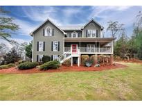 Charming two-story home with covered porch, a red door, and a beautifully landscaped front yard at 2691 Jamerson Rd, Marietta, GA 30066