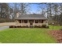 Charming single-story home with a welcoming front porch and well-manicured lawn at 2960 Sandstone Sw Trl, Marietta, GA 30064