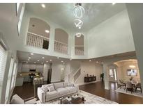 Spacious living room featuring high ceilings, modern lighting, and an open floor plan at 868 Still Hill Ln, Lawrenceville, GA 30045