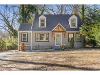 Charming home featuring dormer windows, a well-maintained yard, and a stylish front door at 1824 Westwood Sw Ave, Atlanta, GA 30310