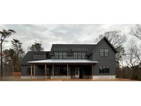 Modern farmhouse-style home with board and batten siding, stone accents, and a welcoming covered front porch at 157 Palisade Dr, Rydal, GA 30171
