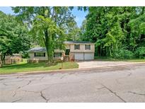 Charming split-level home with a well-maintained lawn and lush trees in a quiet neighborhood at 467 Pineburr Ln, Stone Mountain, GA 30087