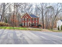 Traditional two-story brick home with black shutters and a manicured front lawn at 1975 Skidmore Cir, Lawrenceville, GA 30044