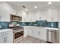 Bright kitchen with stainless steel appliances, white cabinetry, and stylish backsplash at 120 Arrowood Ln, Alpharetta, GA 30009