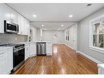 Bright kitchen features stainless appliances, white cabinets, and hardwood floors in an open floor plan at 207 Garrison Se Rd, Marietta, GA 30008